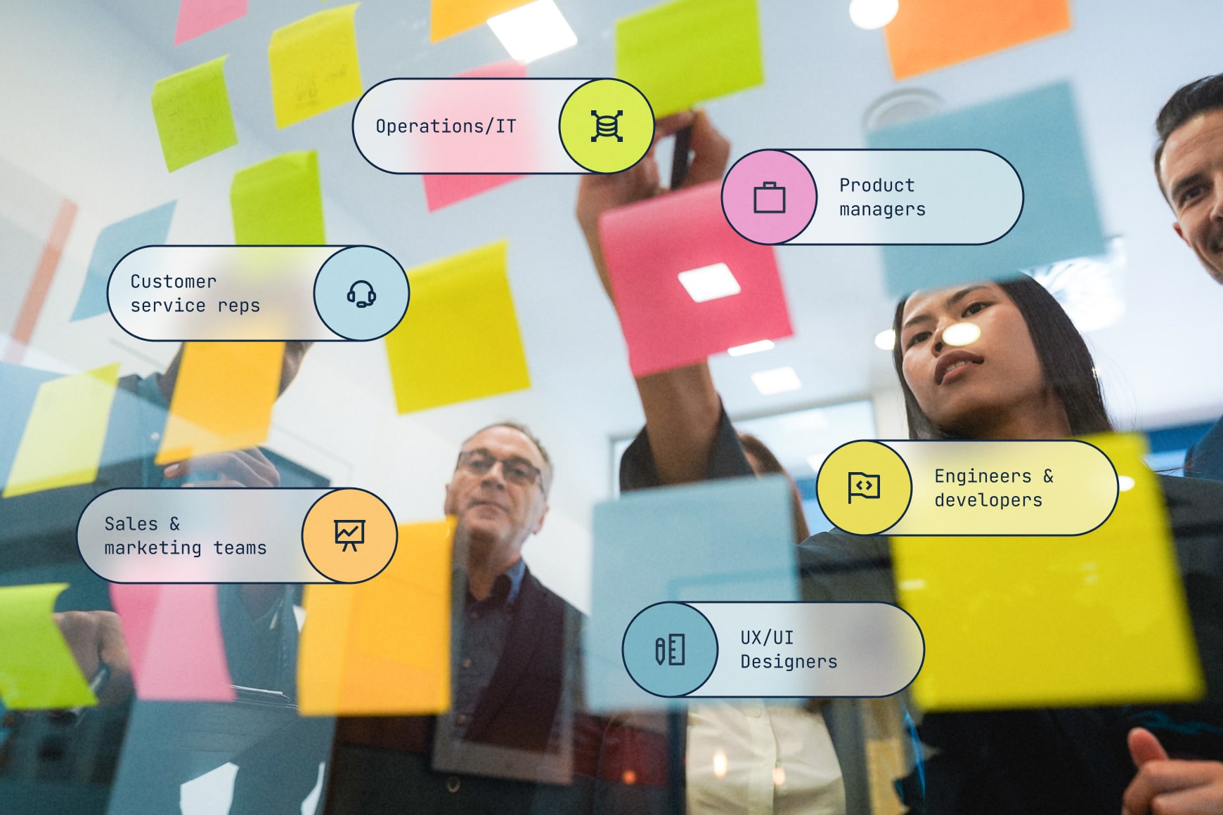 Team working on user story map in office with sticky notes on glass